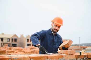 Construction worker in uniform and safety equipment have job on building. Industrial theme.