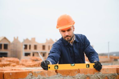 Construction worker in uniform and safety equipment have job on building. Industrial theme.