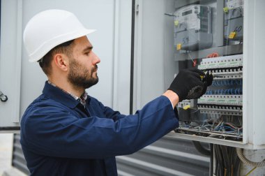 Neşeli elektrikçi dışarıda elektrik santrali kuruyor..