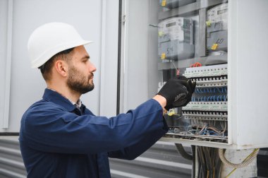 Elektrik mühendisi güç dağıtım kutusu kurulumunu onaylıyor.