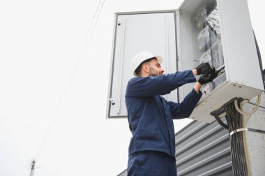 Elektrik mühendisi güç dağıtım kutusu kurulumunu onaylıyor.