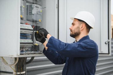 Neşeli elektrikçi dışarıda elektrik santrali kuruyor..