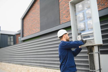 Elektrik mühendisi güç dağıtım kutusu kurulumunu onaylıyor.