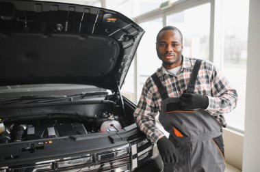 Servis istasyonunda çalışan yetenekli bir teknisyen, araba tamir ediyor..