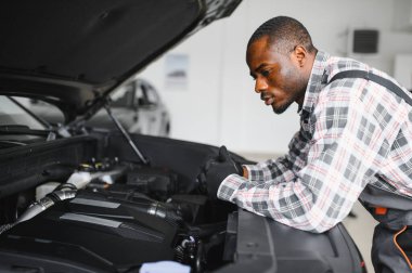 Servis istasyonunda çalışan yetenekli bir teknisyen, araba tamir ediyor..