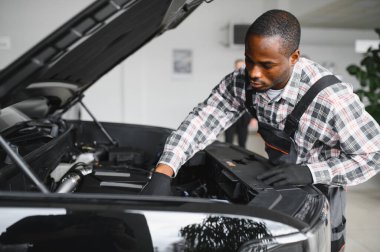 Gülümseyen araba tamircisi oto tamir servisinde.