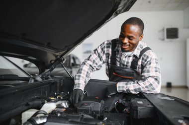 Gülümseyen araba tamircisi oto tamir servisinde.