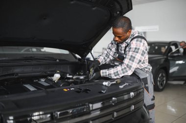 Servis istasyonunda çalışan yetenekli bir teknisyen, araba tamir ediyor..