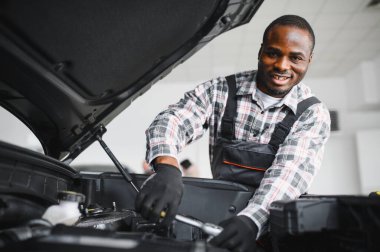 Servis istasyonunda çalışan yetenekli bir teknisyen, araba tamir ediyor..