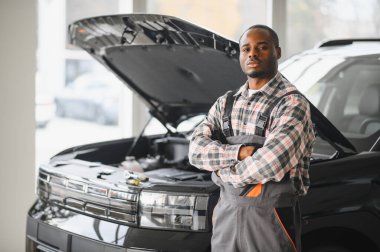 Servis istasyonunda çalışan yetenekli bir teknisyen, araba tamir ediyor..