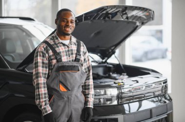 Servis istasyonunda çalışan yetenekli bir teknisyen, araba tamir ediyor..