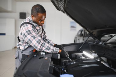 Üniformalı Afro-Amerikan otomobil tamircisinin portresi, arabaları, otomobilleri tamir etmeye hevesli..