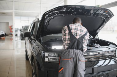 Üniformalı Afro-Amerikan otomobil tamircisinin portresi, arabaları, otomobilleri tamir etmeye hevesli..