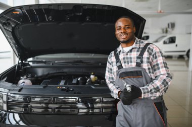 Servis istasyonunda çalışan yetenekli bir teknisyen, araba tamir ediyor..