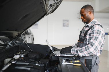 Gülümseyen araba tamircisi oto tamir servisinde.