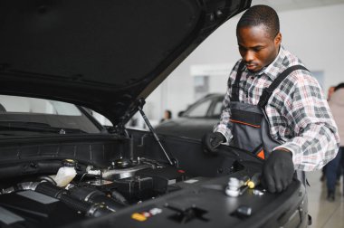 Servis istasyonunda çalışan yetenekli bir teknisyen, araba tamir ediyor..