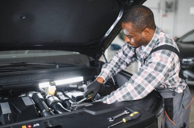 Servis istasyonunda çalışan yetenekli bir teknisyen, araba tamir ediyor..