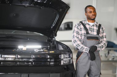 Servis istasyonunda çalışan yetenekli bir teknisyen, araba tamir ediyor..