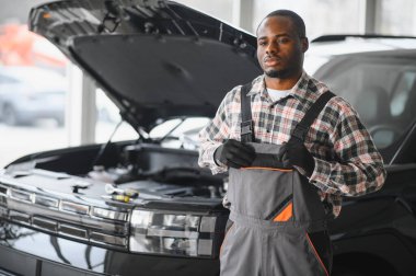 Servis istasyonunda çalışan yetenekli bir teknisyen, araba tamir ediyor..