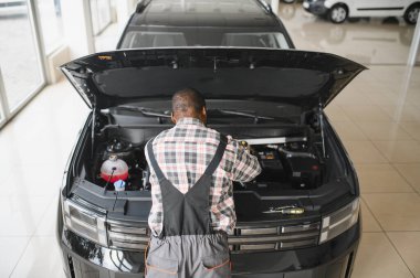 Üniformalı Afro-Amerikan otomobil tamircisinin portresi, arabaları, otomobilleri tamir etmeye hevesli..