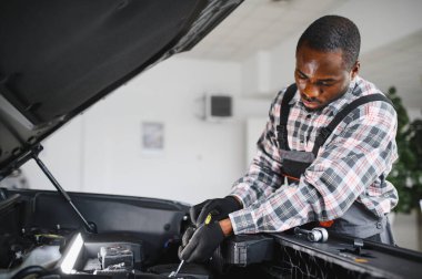 Üniformalı Afro-Amerikan otomobil tamircisinin portresi, arabaları, otomobilleri tamir etmeye hevesli..