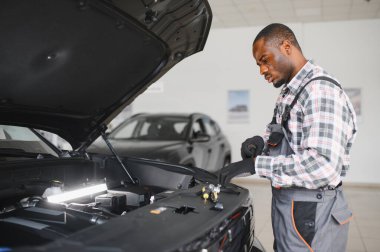 Servis istasyonunda çalışan yetenekli bir teknisyen, araba tamir ediyor..