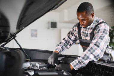 Servis istasyonunda çalışan yetenekli bir teknisyen, araba tamir ediyor..
