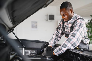 Gülümseyen araba tamircisi oto tamir servisinde.