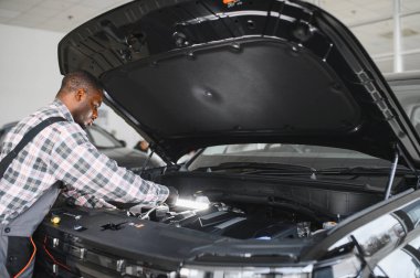 Servis istasyonunda çalışan yetenekli bir teknisyen, araba tamir ediyor..