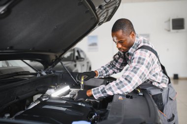 Servis istasyonunda çalışan yetenekli bir teknisyen, araba tamir ediyor..