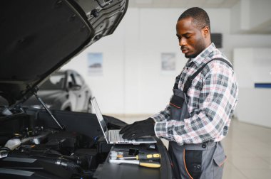 Gülümseyen araba tamircisi oto tamir servisinde.