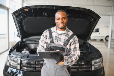 Servis istasyonunda çalışan yetenekli bir teknisyen, araba tamir ediyor..