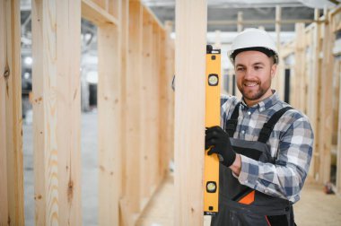 Modüler evlerin yapımı. Üniformalı ve inşaat alanında çalışan erkek inşaat işçisi..