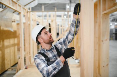 Bir marangoz modüler evler inşaatında çalışır..