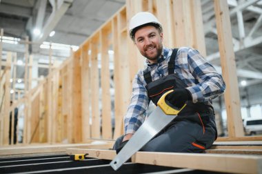 Modern modüler ev. Bir işçi ahşap bir evin inşaatında çalışıyor..