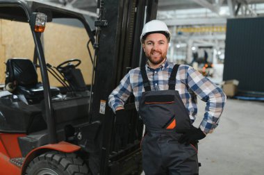 Gülümseyen bir forklift sürücüsü portresi.