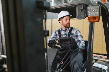 Gülümseyen bir forklift sürücüsü portresi.