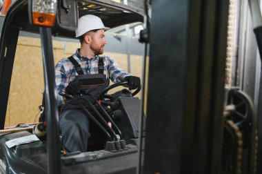 Gülümseyen bir forklift sürücüsü portresi.