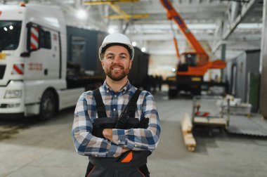 Bir işçi modüler evi kamyona yükleme işlemini kontrol eder. Ulaşım ve teslimat kavramı.