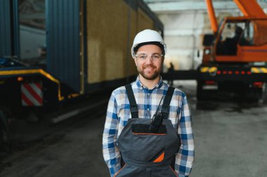 Bir işçi modüler evi kamyona yükleme işlemini kontrol eder. Ulaşım ve teslimat kavramı.