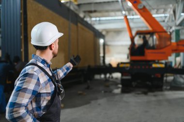 Bir işçi modüler evi kamyona yükleme işlemini kontrol eder. Ulaşım ve teslimat kavramı.