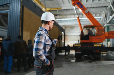 Bir işçi modüler evi kamyona yükleme işlemini kontrol eder. Ulaşım ve teslimat kavramı.