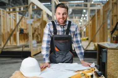 Modüler evlerin yapımı. İnşaat alanındaki bir mimar planlara bakar..