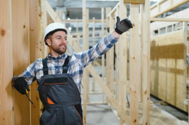 Bir marangoz modüler evler inşaatında çalışır..