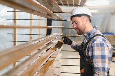 Vernikli ahşap tahtalar işleniyor.