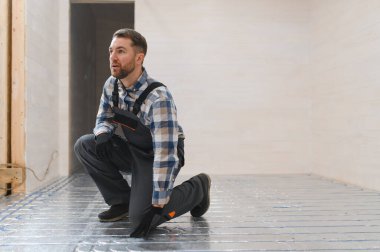 Servis elemanı zeminin altına ısıtma sistemi kuruyor..