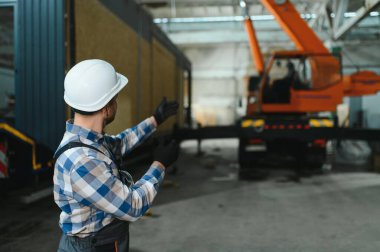 Bir işçi modüler evi kamyona yükleme işlemini kontrol eder. Ulaşım ve teslimat kavramı.