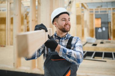 Modern modüler ev. Bir işçi ahşap bir evin inşaatında çalışıyor..