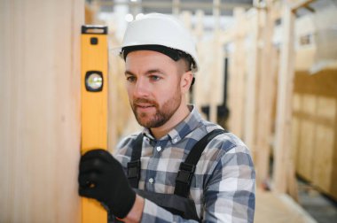 Bir marangoz modüler evler inşaatında çalışır..