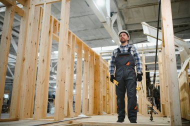 Modern modüler ev. Bir işçi ahşap bir evin inşaatında çalışıyor..